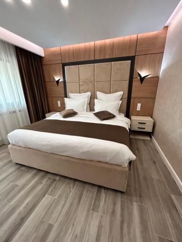 a bedroom with a large bed with a wooden headboard at MONARC Boutique ApartHotel - SELF CHECK-IN in Iaşi