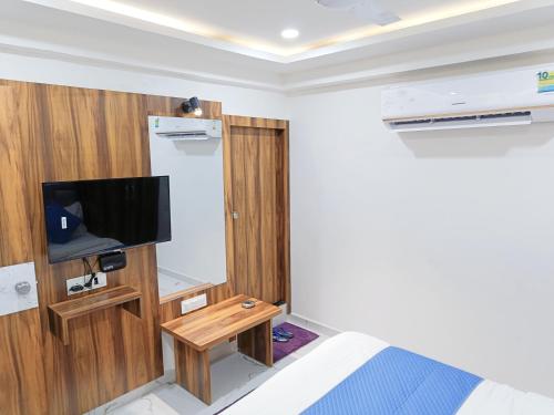 um pequeno quarto com uma cama e uma televisão em HOTEL ROYAL GRAND em Ahmedabad