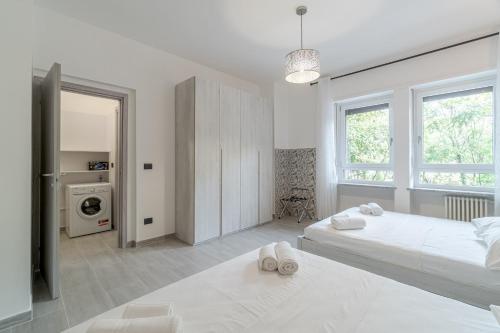 - une chambre blanche avec 2 lits et une fenêtre dans l'établissement Welcome to Turin! Apartment Regina Margherita, à Turin