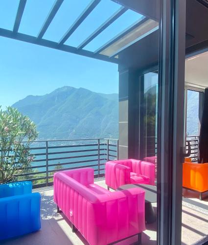 ネッソにあるLake Como Ti Amoの眺めの良いバルコニーにピンクの椅子が置かれた部屋
