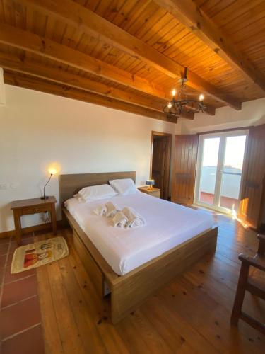 um quarto com uma grande cama branca em um quarto em Casal Serrano Charme e Tranquilidade em Reguengo Grande