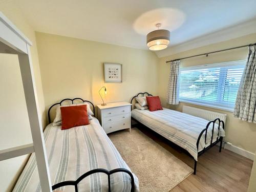 two beds in a bedroom with a window at Pass the Keys Pembroke Dock Hidden Gem in Pembroke Dock