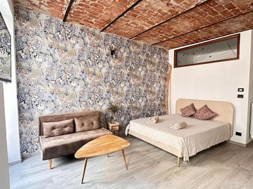 a bedroom with a bed and a couch at Nel cuore del centro storico in Cuneo