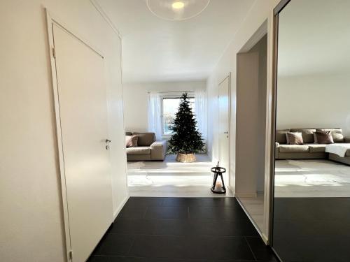 Un pasillo que conduce a una sala de estar con un árbol de Navidad. en Arctic Luxury Apartment, en Rovaniemi