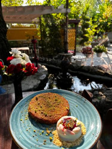 a plate with a piece of cake on a table at Qafqaz Fountain Villa in Gabala
