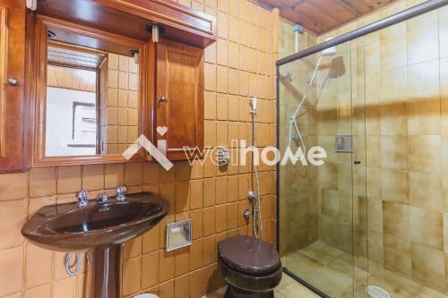 y baño con lavabo y ducha. en Casa com linda vista em Campos do Jordão, en Campos do Jordão
