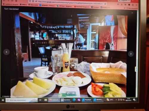 Una mesa con platos de comida en una pantalla de computadora. en Club Haus 502 Kalocsa, en Kalocsa