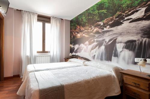 a bedroom with two beds with a waterfall mural on the wall at Hotel Rural Rio Viejo in Cubillas de Arbas