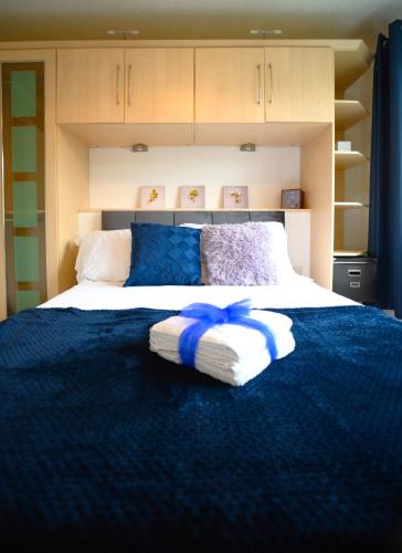 a bedroom with a large bed with a blue blanket at Charming 2-bedroom House near Bourton Park in Buckingham in Buckingham