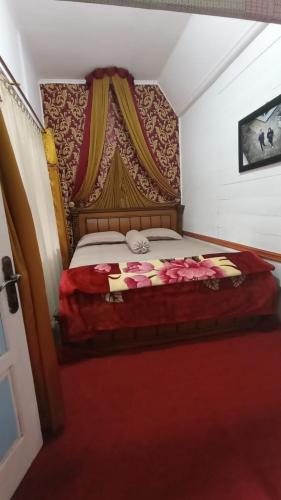 - une chambre avec un lit à baldaquin dans l'établissement Rumah Gadang Homstay, à Baso