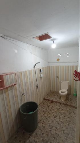 La salle de bains est pourvue de toilettes et d'un seau. dans l'établissement Rumah Gadang Homstay, à Baso