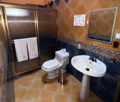 a bathroom with a toilet and a sink at Rancho San Antonio in Salento