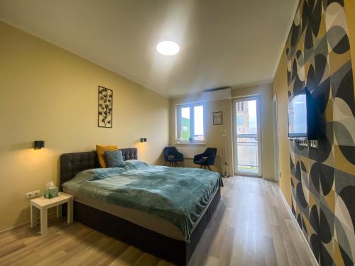 ein Schlafzimmer mit einem Bett und einem TV an der Wand in der Unterkunft Fresh smartly designed Studio Flat & sunny balcony in Budapest