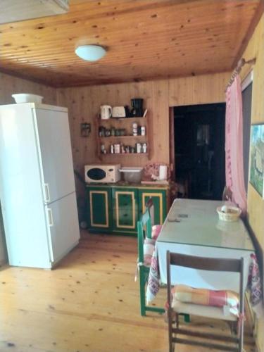 a kitchen with a table and a refrigerator in a room at σπίτι - αγρόκτημα - Δ Γεωργά Χατζηράση οδός Χατζηράση in Porto Heli