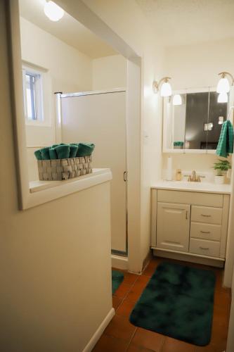 a bathroom with a sink and a shower with a mirror at Hot Air Balloon Haven, Hot Tub, King Bed, Office, Foosball, Bball in Albuquerque