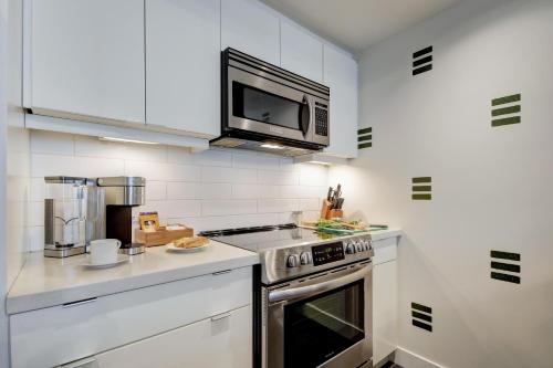 a kitchen with a stove and a microwave at Coastal Creative Condo in Victoria