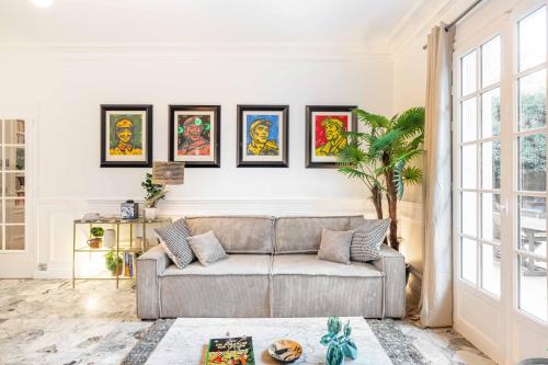 a living room with a couch and paintings on the wall at Grand & Classy Apartment with Private Garden, Villa des Ammonites in Meudon