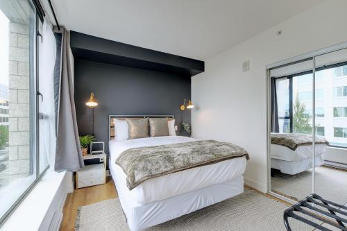 - une chambre avec un grand lit et une fenêtre dans l'établissement Coastal Creative Condo, à Victoria
