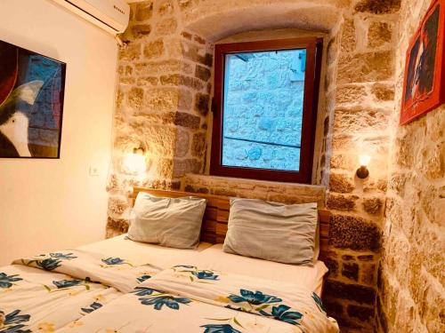 een slaapkamer met 2 bedden en een raam bij The Way Up in Kotor