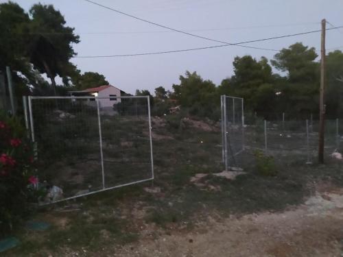 a fence with a basketball hoop in a yard at σπίτι - αγρόκτημα in Porto Heli
