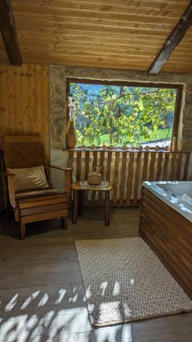 a room with a tub and a chair and a window at Etno Vila Kula in Malo Središte