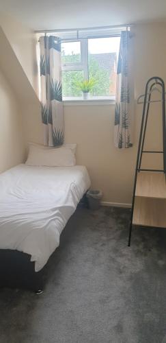 a bedroom with a bed and a ladder next to a window at The Grove - 3 Bed updated detached house- sleeps upto 8 guests- West Midlands in Fallings Park
