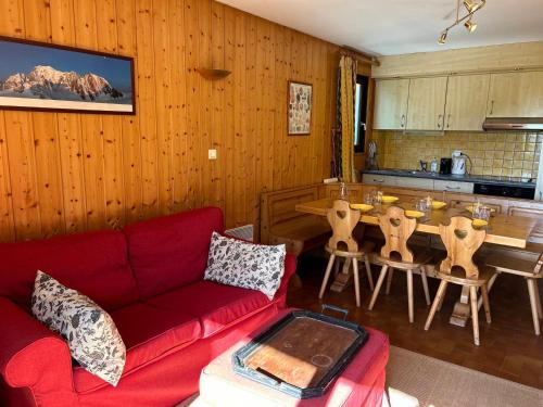 un salon avec un canapé rouge et une table dans l'établissement Appartement spacieux aux Gets, pied des pistes, balcon sud-ouest, 2 chambres, coin cabine, garage, WiFi - FR-1-623-81, aux Gets