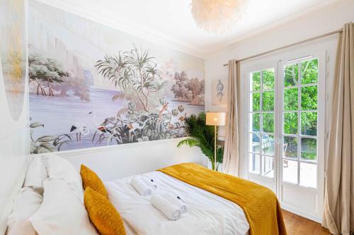 a bedroom with a bed with a painting on the wall at Grand & Classy Apartment with Private Garden, Villa des Ammonites in Meudon