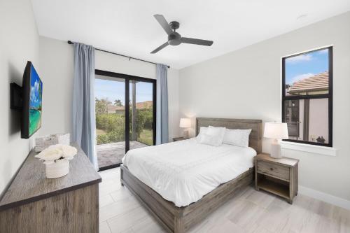 Un dormitorio con una cama y una ventana grande en Marco Coastal Luxury | Pool, Spa and Outdoor Kitchen, en Marco Island