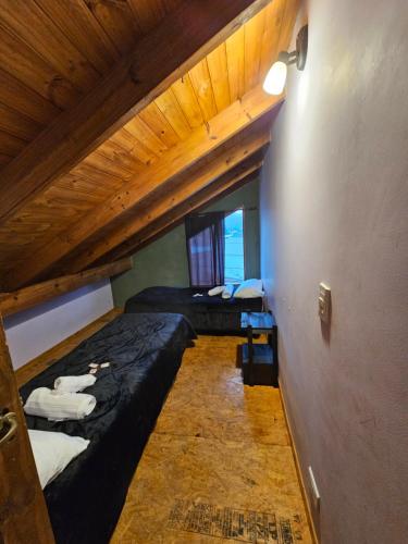 Dos literas en una habitación con techos de madera. en Valentyna Aparts El Chalten 4, en El Chaltén