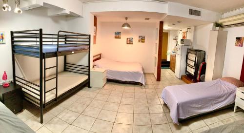 a room with two bunk beds and a kitchen at Dotan's Boutique Guesthouse - By The Beach! in Tel Aviv