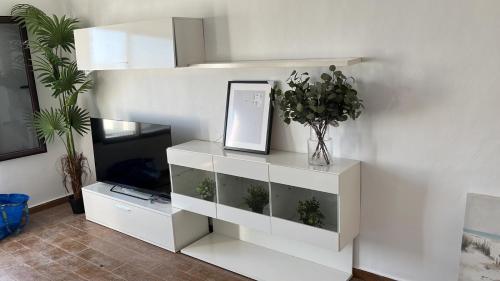 a living room with a white entertainment center with a tv at Apartamento con amplia terraza en la playa in Puerto del Carmen