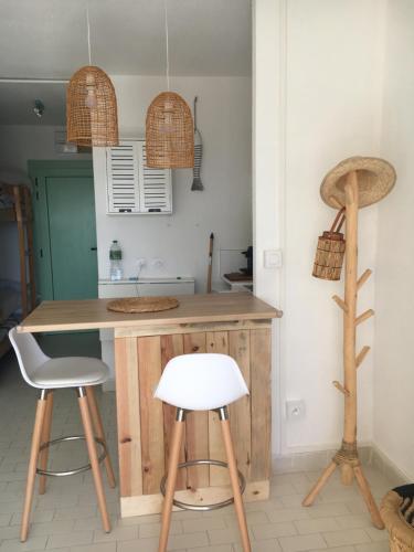 a kitchen with a wooden counter and two stools at Très joli studio 4 personnes avec terrasse front de mer in Leucate