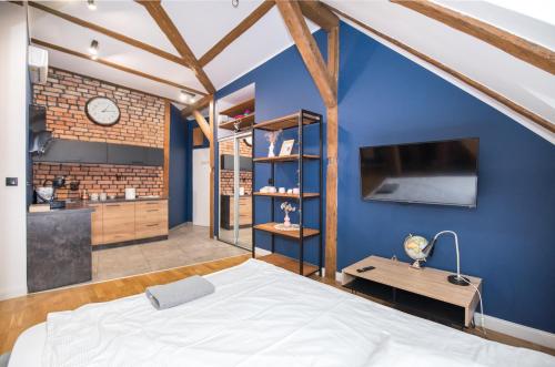 a bedroom with a bed and a blue wall at Przytulny Apartament Z Wieżą in Gliwice