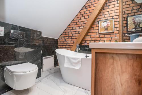 a bathroom with a white toilet and a sink at Przytulny Apartament Z Wieżą in Gliwice