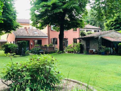 une grande maison avec une cour avec une pelouse dans l'établissement La Casa di Marina, à Ferrare