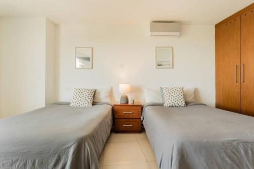 two beds sitting next to each other in a bedroom at BLUE DREAM Beachfront 2 BDR by Casa Paraiso in Cancún