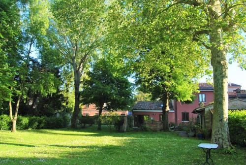 une cour avec une maison rose et des arbres dans l'établissement La Casa di Marina, à Ferrare
