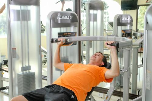 a man lifting a bar in a gym at Sea Links Beach Hotel in Mui Ne