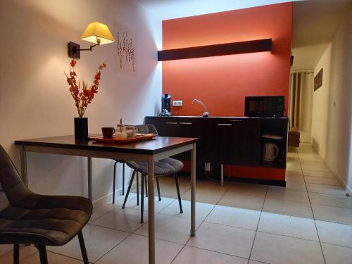 una sala da pranzo con tavolo e sedie e una cucina di Hebergement confort Comfortlogies La Fontanella a La-Roche-en-Ardenne