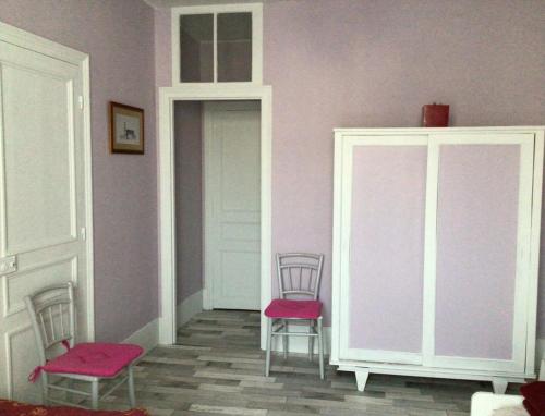 een kamer met 2 stoelen en paarse muren bij Homelière in Villeneuve-sur-Bellot