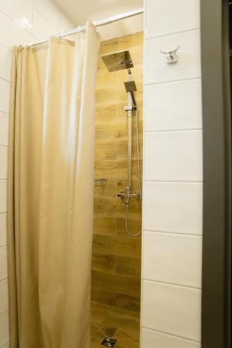 a shower with a shower curtain in a bathroom at Nicolas Resort Club in Kyiv
