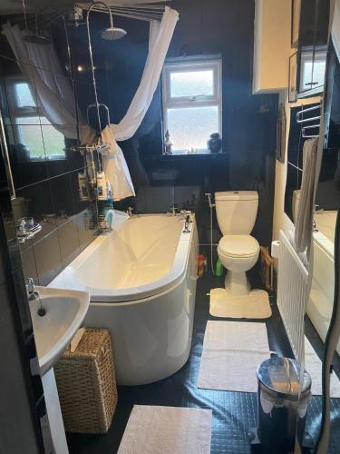 uma casa de banho com uma banheira, um WC e um lavatório. em Bellhay Orchard em Glastonbury