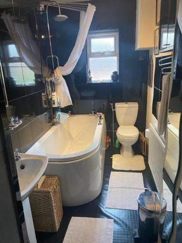 a bathroom with a tub and a toilet and a sink at Bellhay Orchard in Glastonbury