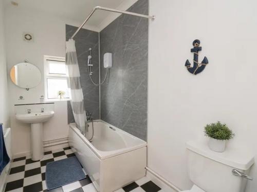 a bathroom with a sink and a toilet and a tub at 2 bedroom holiday home in the heart of west wales in St Clears