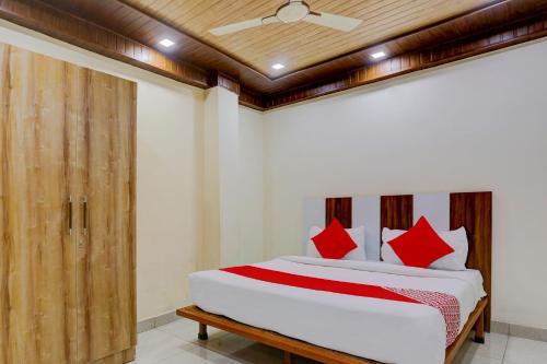 a bedroom with a large bed with red pillows at Super OYO Flagship Hotel Family Deluxe in New Delhi