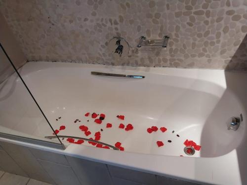 a bath tub with red flowers on the side of it at Emufuleni river logde in Vanderbijlpark