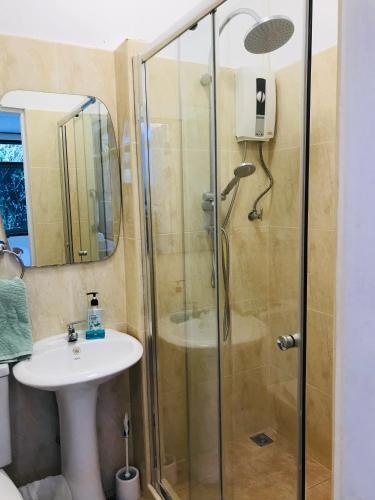 a bathroom with a shower and a sink at Master Bedroom with private bathroom and kitchen in Phuket
