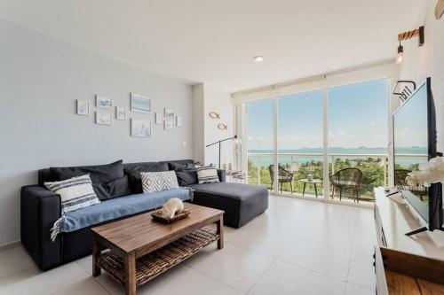 a living room with a couch and a table at ☆BLUE NEST- Beachfront apartment by CASA PARAISO☆ in Cancún