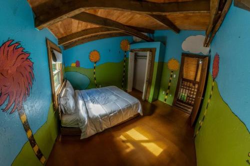 にあるSerenity on Seven Acres - Luxurious Log Cabinの壁画のある部屋のベッド1台が備わるベッドルーム1室を利用します。